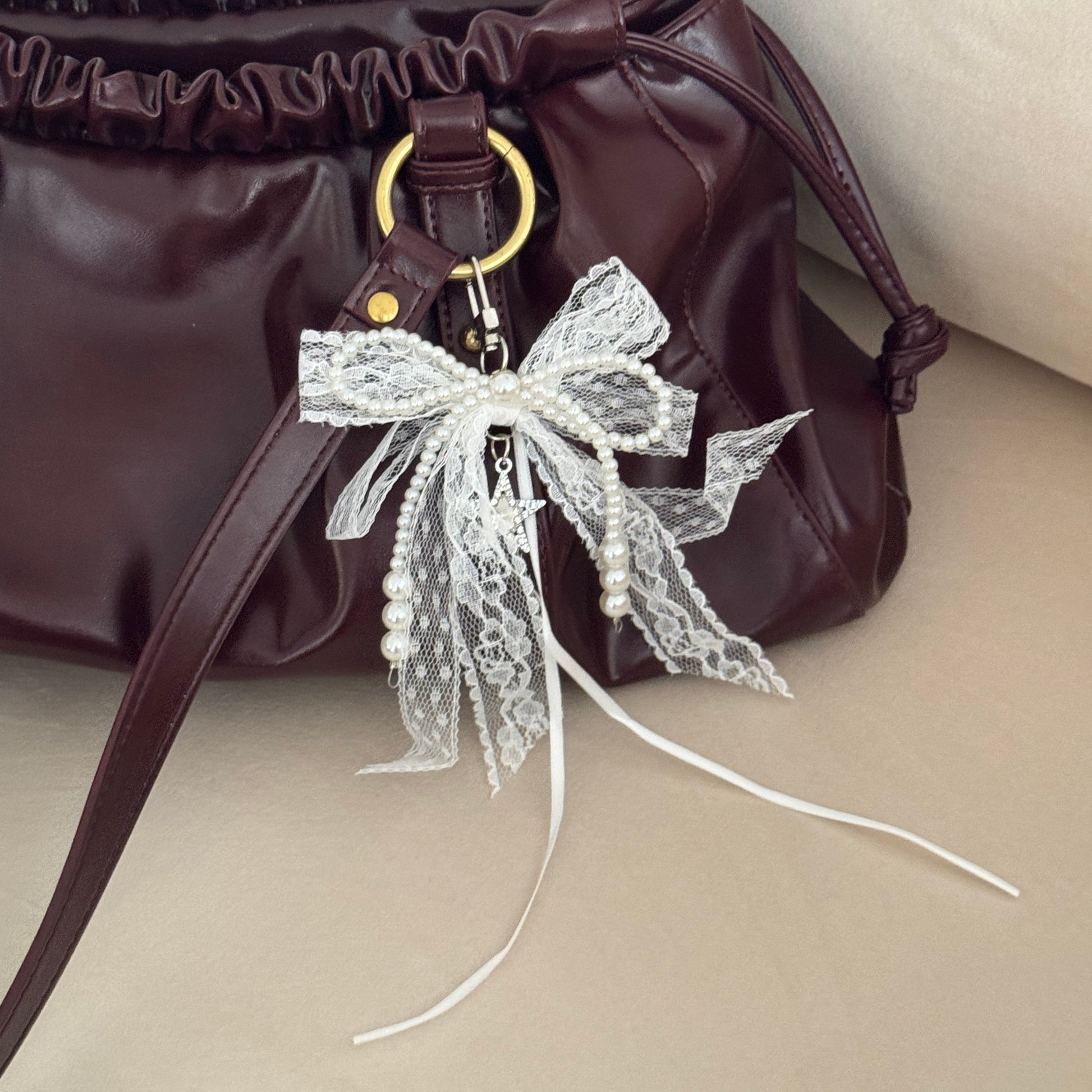 Brown handbag with decorative bow on a beige background